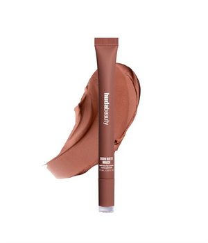Brown lip balm tube with a swatch of color on a white background
