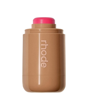 A brown makeup stick with a bright pink cap, featuring the vertical rhode logo on the front, set against a plain white background.