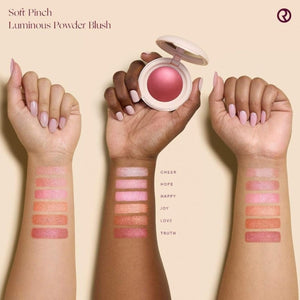 Luminous Powder Blush with swatches on arms against a beige background