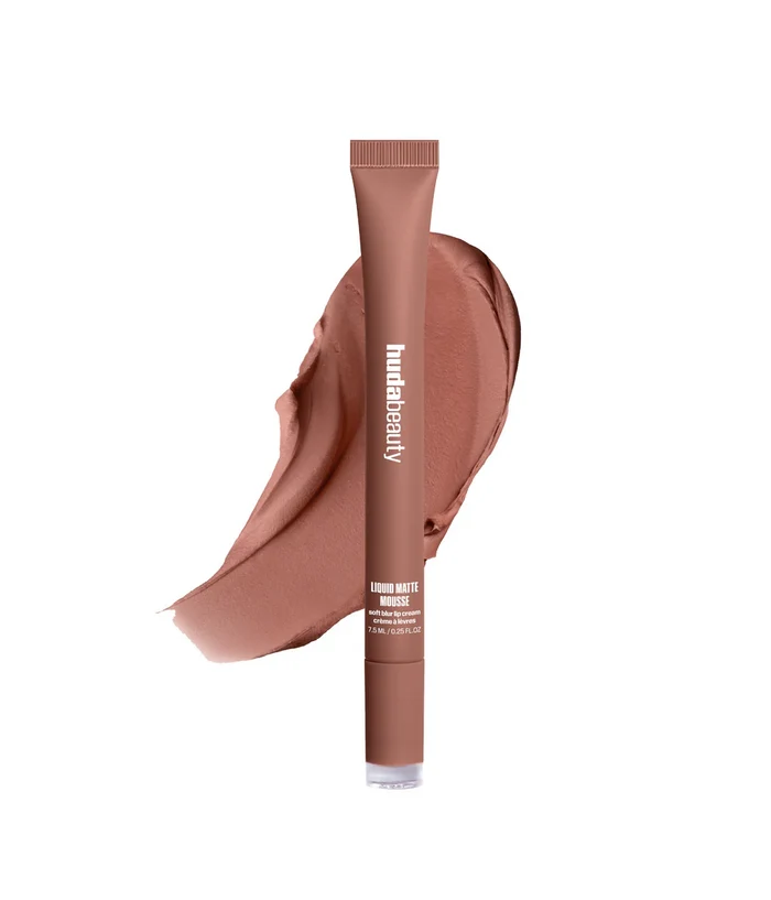 A tube of humateauty bronzer makeup in a warm medium brown shade, shown upright in front of a matching makeup smear on a plain white background.