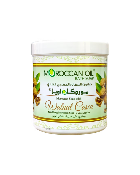 A white plastic jar of Moroccan Oil Bath Soap in Walnut Casca scent, featuring a light green and white label with illustrations of almonds and green leaves.
