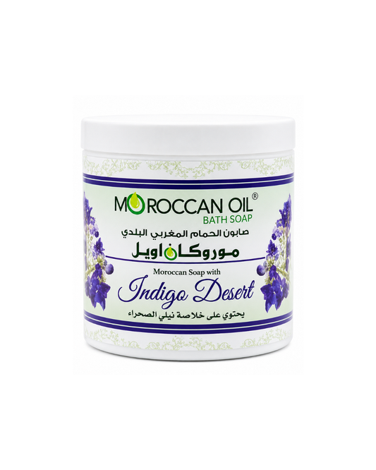 A white plastic jar of Moroccan Oil Bath Soap, specifically the 'Indigo Desert' variant, featuring a white label with purple and green accents and Arabic text.