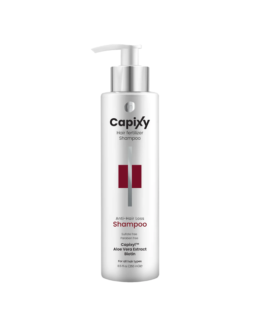 A bottle of Capixy Hair Fertilizer Shampoo with a white pump dispenser and silver cap, featuring red and black text on a white background.